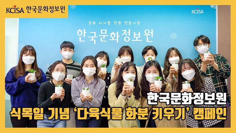 한국문화정보원 신규직원들이 원장님과 함께 다육식물을 들고 웃고 있는 사진입니다.